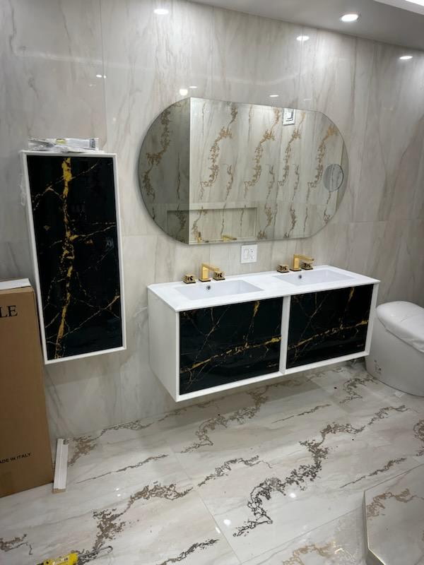 Double floating vanity with black and gold marble-look fronts, twin sinks and gold faucets